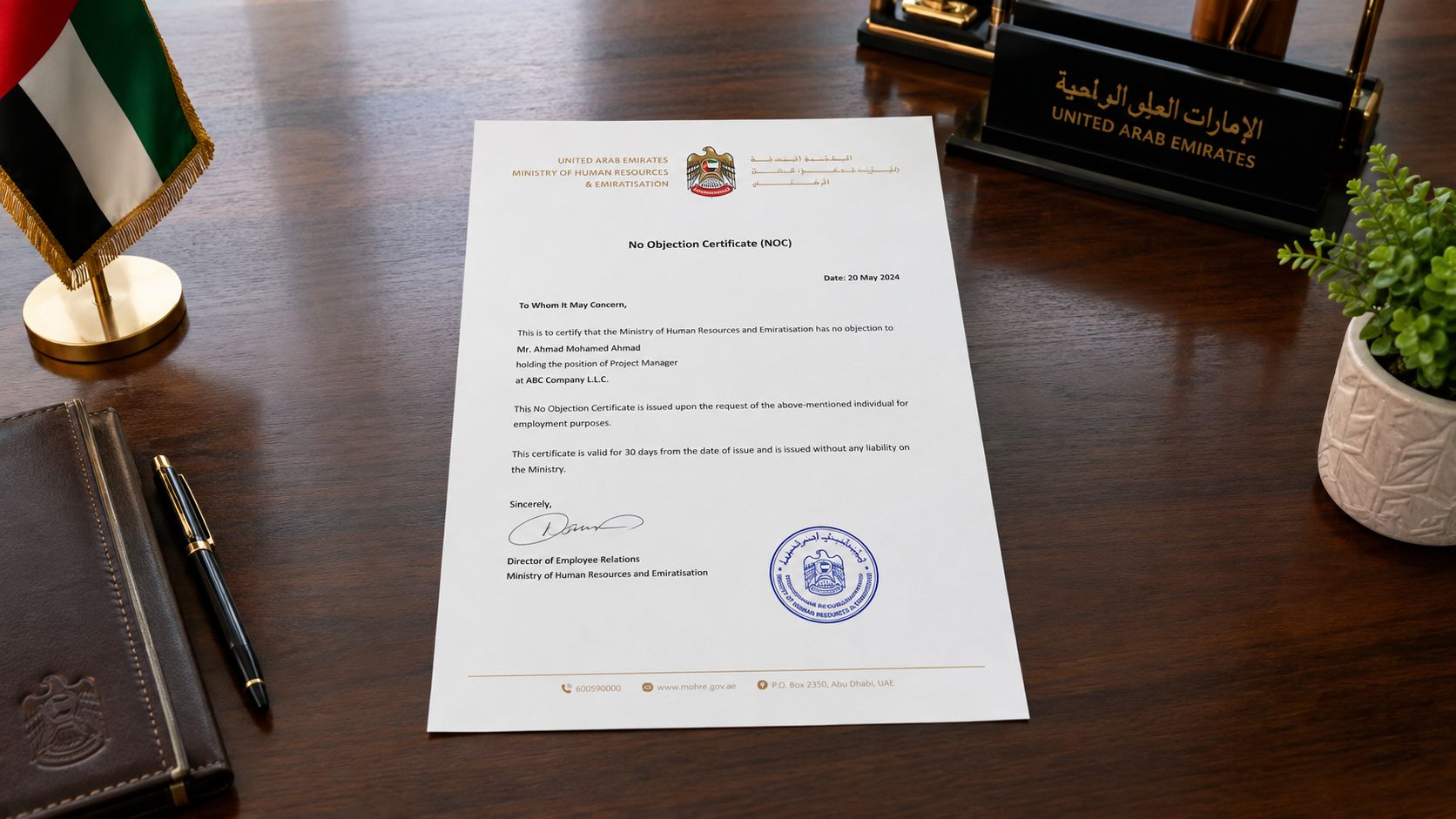 A printed Ministry of Human Resources and Emiratisation No Objection Certificate placed on a professional wooden desk.
